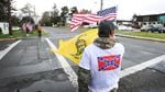 Trentin Smith holds an American flag and the "Don't Tread On Me" flag across the street from North Bend High School on Monday, Feb. 6, 2017.