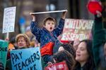 5 year old Joaquin Freiberg cheers above the crowd, hoisting a sign which reads, "Teachers help kids play, grow, and learn!" Full story here.