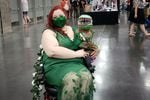 Jenny Skelton poses in Poison Ivy and Audrey II costumes at the Oregon Convention Center in Portland, Oregon on September 9, 2022. Several attendees are dressed in Rose City Comic Con costumes.