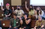 Opponents of a proposed camping ban snap their fingers, agreeing with testimony at a Portland City Council meeting in Portland, May 31, 2023. 