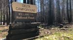A sign noting the Delta Campground in front of burned trees.