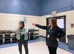 Yaquina View Elementary School principal Kristin Takano Becker, left, and Lincoln County School District Communications Coordinator Kristin Bigler inside the current Yaquina View gym. The gym currently serves as a cafeteria and gym for students at the school.