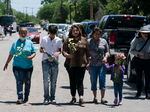 People walk with flowers to honor the victims in Tuesday's shooting at Robb Elementary School in Uvalde, Texas, Wednesday, May 25, 2022.