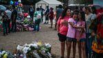 People mourn Tuesday at a makeshift memorial for the victims of the Robb Elementary School shooting in Uvalde, Texas. The Texas town of Uvalde began on Tuesday laying to rest the 19 young children killed in an elementary school shooting that left the small, tight-knit community united in grief and anger.
