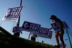 Supporters of a constitutional amendment about abortion in Kansas remove signs ahead of Tuesday's vote.