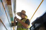 Alex Chiu paints a small portion of his mural on NE 82nd Ave. 