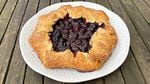 A marionberry galette with folded edges encrusted in sugar.