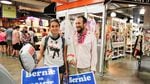 Vanessa Perez, left, of Florida, and Niko Klein, right, of San Francisco, are decked out in pins, stickers, signs and a flag showing their support for Bernie Sanders in the Reading Terminal Market.