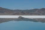 Salt deposits float as the mountains are reflected in a lithium brine evaporation pool at Silver Peak lithium mine in Silver Peak, Nev. on Oct. 6, 2022.