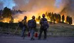 Firefighters watch a hillside burn on the Northern Cheyenne Indian Reservation, Wednesday, Aug 11, 2021, near Lame Deer, Mont. The Richard Spring fire was threatening hundreds of homes as it burned across the reservation.