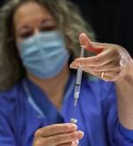 Kelly Beckley, RN, prepares the Pfizer vaccine ahead of the opening of a COVID-19 vaccination clinic being held at the Oregon Convention Center, Jan. 27, 2021. The clinic is supported by Portland's four health systems and aimed to give 2,000 vaccinations per day to pre-registered recipients. 