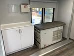 Two small examination rooms inside the mobile clinic include examination tables and medical equipment.