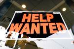 A sign posted in a window reads "Help Wanted."