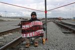 Portland Riding Tide activist Nick Haas sits handcuffed to a tripod that was built in the middle of Terminal 5 rail line Thursday, Oct. 17, 2019, at the Port of Vancouver. Activists blocked railroad tracks at the port in attempt to stop a train carrying materials for the Trans Mountain Pipeline Project in Canada.