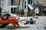 People embrace as they survey property damage on Sept. 29, 2022, in Bonita Springs, Fla.