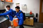 Angel Nuñez (right) and Noah Sanchez fill a Gatorade cooler with water and ice.
