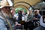 People take a ride in a covered wagon through downtown Portland.