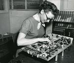 A woman assembles an oscilloscope at Tektronix, ca. 1950s. Many homemakers without job experience were hired and taught a variety of tasks including soldering.