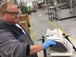 John Clason loads solar cells into a tray to be made into panels at the SolarWorld Americas manufacturing plant in Hillsboro.
