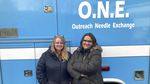 Two women stand in front of an ambulance converted into a mobile needle-exchange unit.