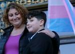 Sara Kaplan, left, hugs her transgender son James, 9, during a rally in support of transgender rights in San Francisco, Thursday, Feb. 23, 2017. Oregon's education department has released new guidance and resources to support LGBTQ+ students in schools.