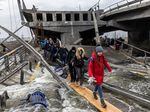Residents of Irpin flee heavy fighting via a destroyed bridge as Russian forces enter the city in March.