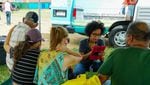 Karla Peña, Mercy Corps’ Puerto Rico director, interviews a family from Guayanilla. This is one of approximately 300 families who have been staying under tarps a municipal stadium.