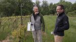 In this video still OSU entomologist Vaughn Walton (right) prepares to install the Pied Piper in May 2023 at the Stag Hollow Winery. Owner Mark Huff (left) holds the device he hopes will eventually help Oregon wineries better control pests.