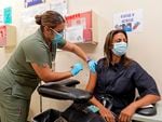 Licensed vocational nurse Denise Saldana vaccinates Pri DeSilva, associate director of Individual and Corporate Giving, with a fourth Pfizer COVID-19 vaccine booster at the Dr. Kenneth Williams Health Center in Los Angeles, Nov. 1, 2022.