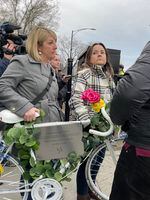 Jaime Bolognone prepare to take a ghost bike honoring her late fiancé, Gerardo Marciales, out into the intersection where he was recently killed.