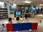 Kids and caretakers watch a "Madeline" DVD in the basement of the Columbia County Library on a hot Tuesday afternoon.