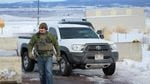 An FBI guard guides a truck out of the compound near the Burns Airport.