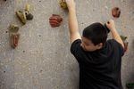 Class Of 2025 student Logan climbs the rock climbing wall at Yoshikai Elementary School, as part of his PE class.