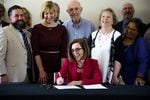 Gov. Kate Brown signs Senate Bill 1008 into law at the June Key Delta Community Center in Portland, Ore., Monday, July 22, 2019. The law brings reform to Oregon's juvenile justice system.