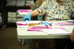 Election workers process ballots that are unreadable by machines due to misprinted barcodes on Saturday, May 22.