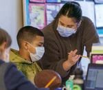 Reyes Lazo, 11, left, works with teacher Jasmine Lowe in a combined fourth- and fifth-grade class at Prescott Elementary in Portland, Feb. 8, 2022. Educators at the Northeast Portland school are working to get students engaged and create a school community—two pieces of education that have been impacted by the long duration of the pandemic.