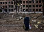 A woman stands in front of a destroyed building after a Russian missile attack in the town of Vasylkiv, near Kyiv, on Feb. 27.