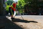 Marty Swinehart picks up litter and debris near SW Columbia Street and SW 13th Avenue in Portland, June 24, 2021. Swinehart says he feels basic city services downtown have gone neglected, including trash collection and storm drain maintenance.