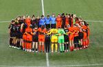 National Women's Soccer league players form a circle on the pitch at Providence Park in Portland.