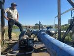 Alan Schreiber inspects his broken irrigation pump. It's only working at 30 percent capacity in 117 heat.