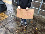 A seventh grader at Metropolitan Learning Center holds a sign reading "Revolution" during the Portland Public Schools student walkout, November 14 2016. 