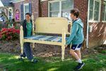 Jenna Fournel and Leal Abbatiello, 14, carry a daybed frame to display their products at their home in Alexandria, Virginia on April 30, 2022.