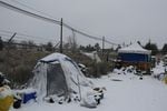 A person occupies a snow-covered tent on the outskirts of Bend, as the outside temperature approaches single digits on Dec. 29, 2021. The city of Bend will implement new rules about where, when and how unhoused people can camp.