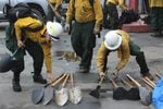 Firefighters with the private contracting outfit Inbound LLC stack shovels and other hand tools at the company's headquarters in Oakridge, Oregon. 