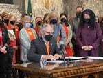 Gov. Jay Inslee prepares to sign gun-related legislation at a bill signing ceremony in the State Reception Room at the Capitol on Wednesday, March 23, 2022. One of the bills bans the manufacture and sale of gun magazines that hold more than 10 rounds of ammunition. 