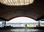 Port of Portland spokesperson Kama Simonds stands beneath a skylight of the airport's new wooden roof, July 5, 2022. Its construction is meant to evoke dappled forest light.