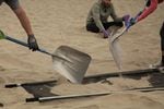 Volunteers scoop sand onto microplastics filtration systems at Cannon Beach.