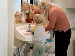Small Wonders Hollywood co-owner and director Natalie Galbraith helps children wash their hands in a toddler classroom.