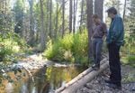 Scott Nicolai, a Yakama Nation habitat biologist, and Dave Morrow, a local landowner, observe juvenile fish in the stream they restored together.