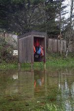 A cabinet of life jackets, free for visitors to borrow, is surrounded by water during a king tide in Nehalem, Oregon. King tides can help city planners envision a future with sea level rise.